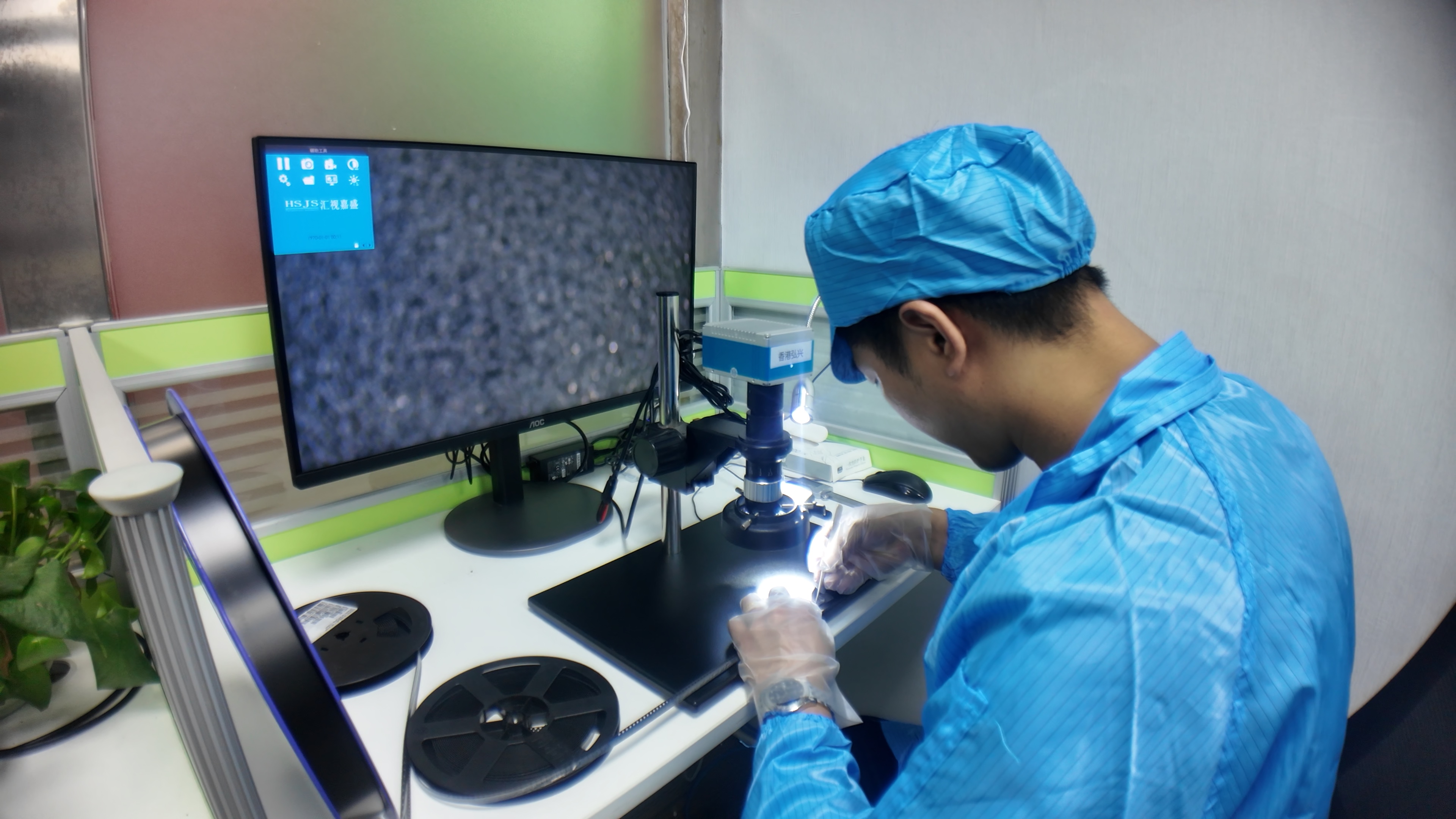 Technician handling a component under the inspection microscope