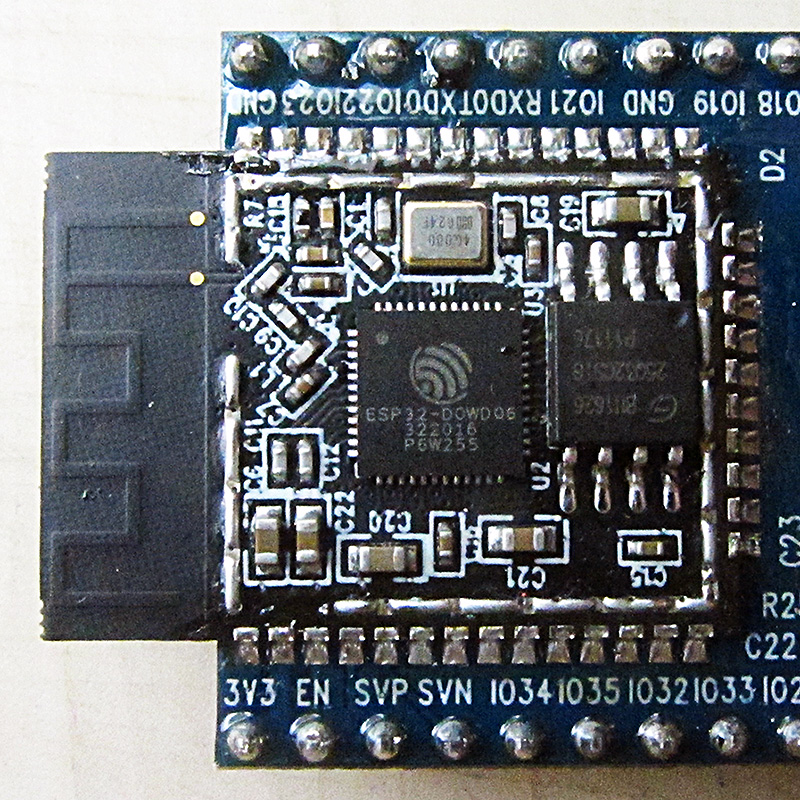 Close-up photograph of an ESP32 Wi-Fi and Bluetooth chip with surface-mount components